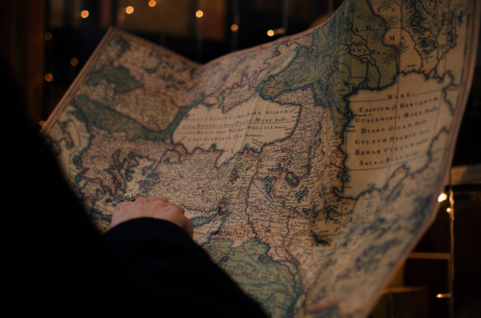 Hands holding an old printed map up to the light