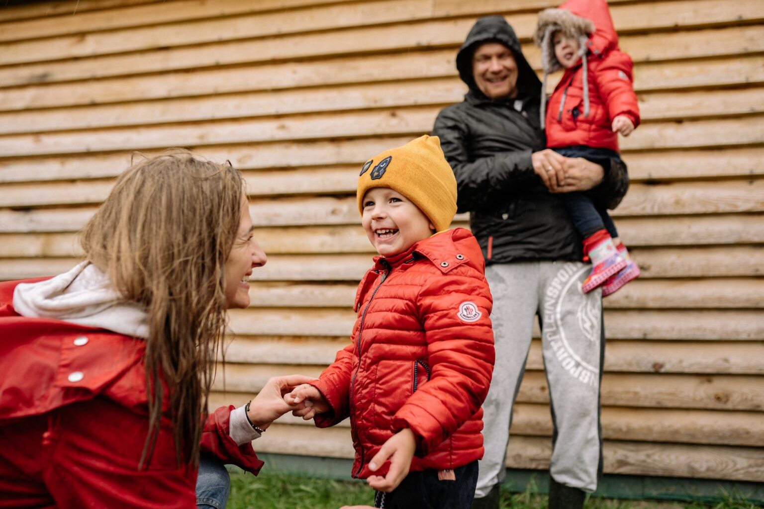 The family laughing outside in their winter coats